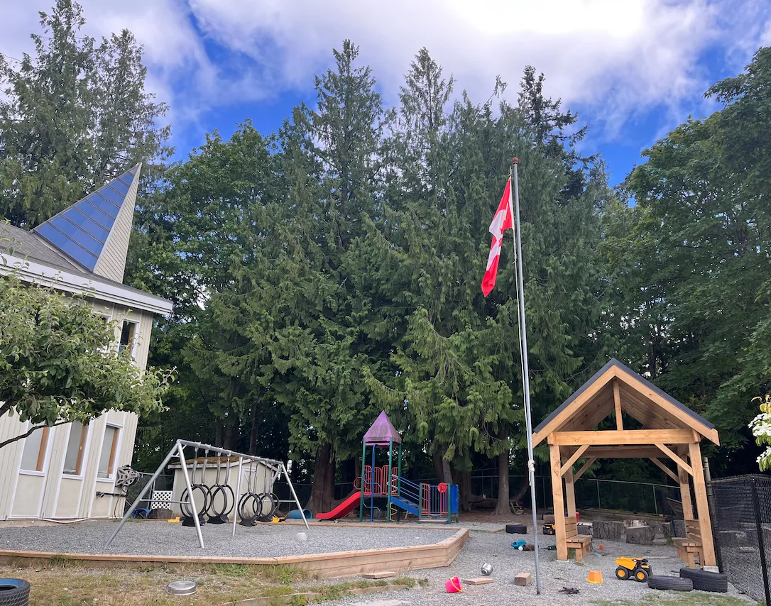 Playground with swings, a slide and a timber-frame gazebo